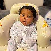 Achilles joined the competition — help win amazing prizes! baby, child, pajamas, white_clothing, mittens, seat, cushion, giraffe_pattern, stars, indoor, portrait, infant, cute, soft_lighting, face, looking_at_camera, sitting, cozy, young_child, adorable