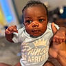 Dakarai joined the competition — help win amazing prizes! baby, infant, child, person, onesie, blue_clothing, hand, face, eyes, indoor, blurred_background, cute, human, portrait, skin, newborn, expression, holding, small_fingers, soft_lighting