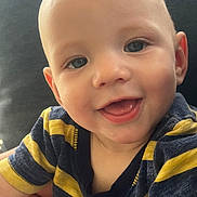 Remmington is registered to the contest to win money with this photo: baby, child, smile, face, portrait, close_up, happy, cute, striped_shirt, navy, yellow, infant, person, skin, eyes, mouth, expression, young, head, indoors
