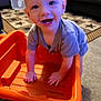 Remmington joined the competition — help win amazing prizes! toddler, child, smiling, indoor, wagon, orange, carpet, furniture, happy, face, hands, toy, crawling, person, living_room, playing, short_hair, cute, carpet_pattern, plastic