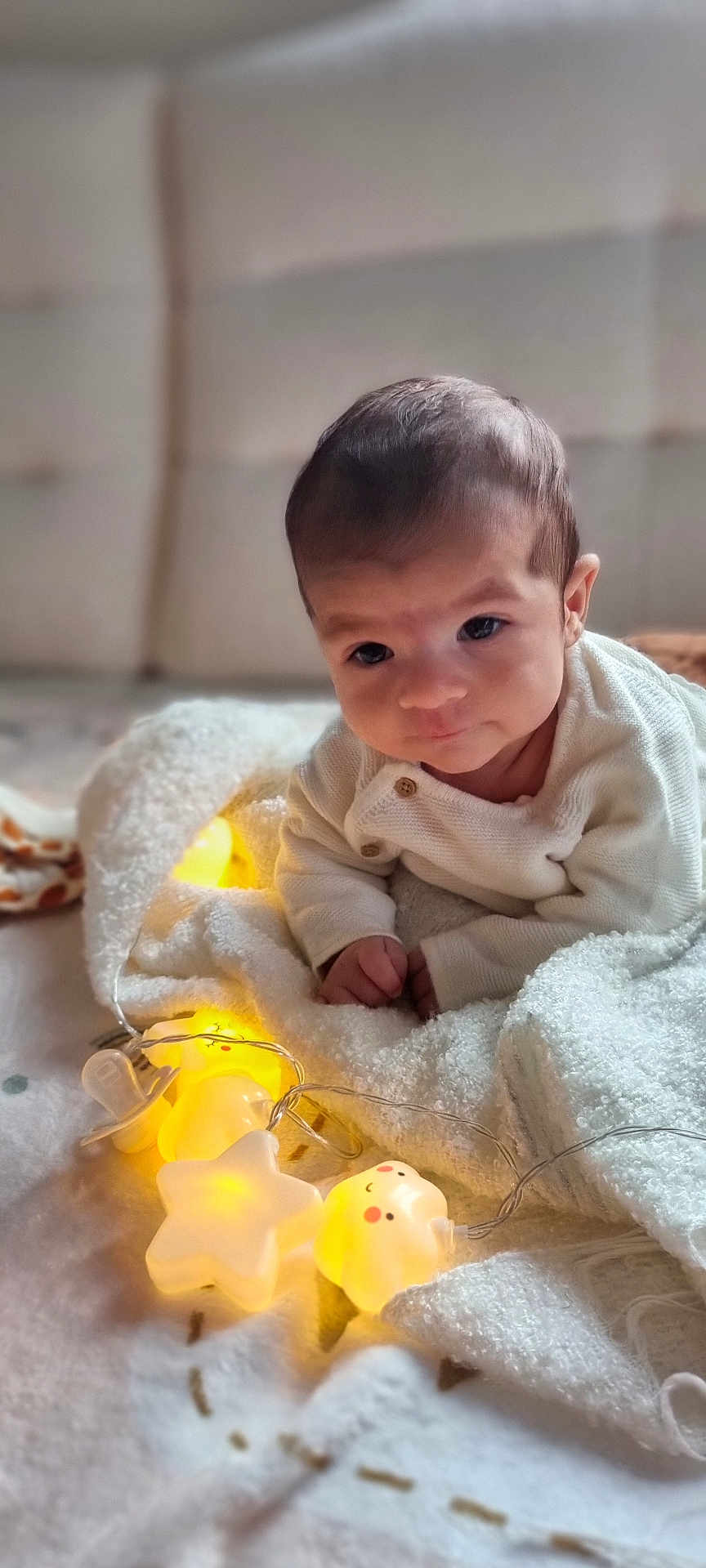 Basile a rejoint le concours — aidez-le/la à gagner de superbes lots ! baby, bear_light, blanket, child, comfort, cozy, cute, expression, face, hand, indoors, infant, lying_down, pacifier, portrait, sleepwear, soft_texture, star_light, string_lights, warm_light