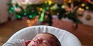 Basile a rejoint le concours — aidez-le/la à gagner de superbes lots ! baby, sleeping, blanket, christmas_tree, holiday, indoors, soft_light, cozy, infant, bokeh, decorations, festive, warm, knit, white_clothing, peaceful, portrait, cute, relaxation, home