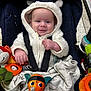 baby, infant, stroller, hooded_jacket, white_clothing, smile, toy, plush_toy, car_seat, child, cute, indoor, shopping_cart, blanket, person, face, happy, small_hands, seatbelt, wearing