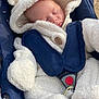 baby, infant, sleeping, onesie, fluffy_clothing, stroller, harness, outdoor, cute, closed_eyes, soft_texture, warm_clothing, headgear, peaceful, baby_accessory, child, small_person, comfort, cocooned, young