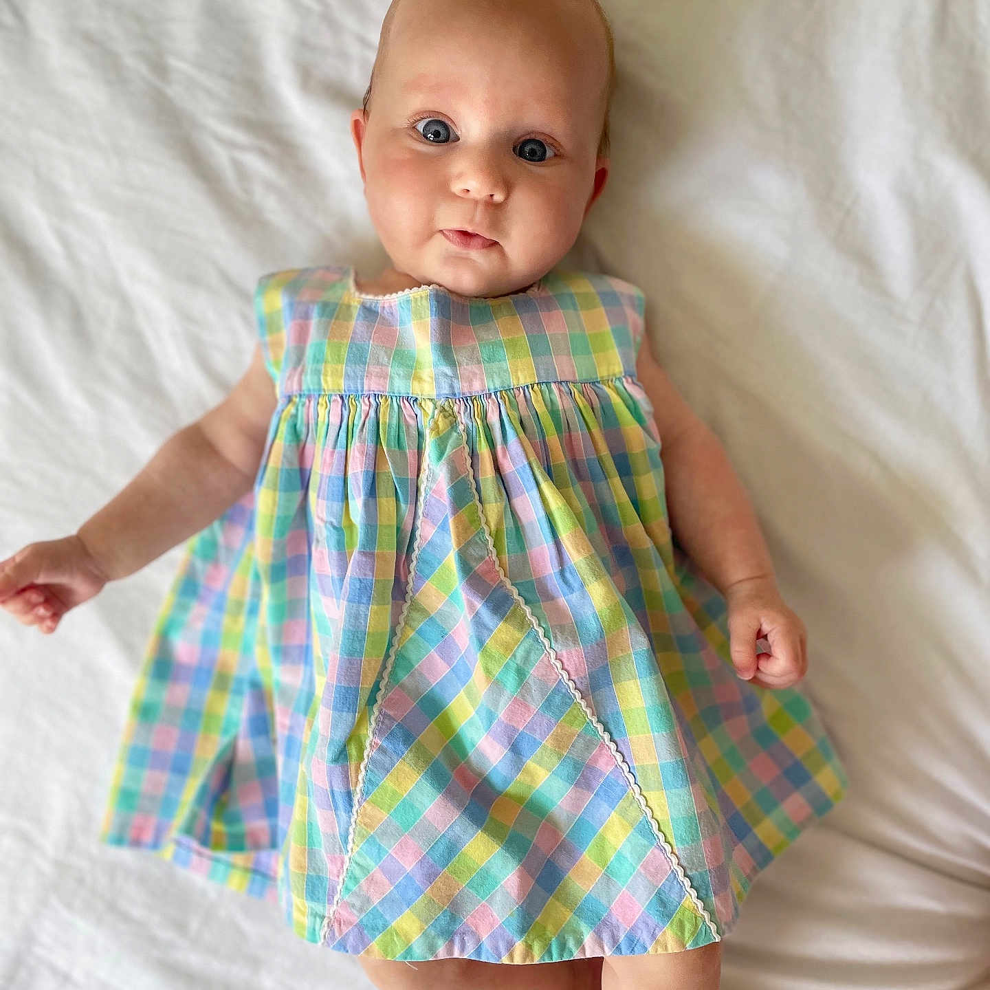 Rose participe au concours pour gagner de l'argent avec cette photo : baby, checkered, child, colorful, cute, dress, eyes, face, hands, indoors, infant, legs, lying_down, pastel, pattern, portrait, skin, smile, soft_light, white_background