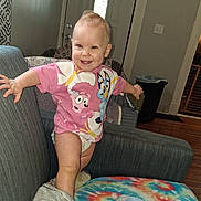 Nevaeh Hatfield joined the competition — help win amazing prizes! toddler, child, baby, smiling, happy, portrait, indoor, armchair, blanket, home, living_room, clothing, pink_shirt, cartoon, standing, arms_outstretched, blonde_hair, face, furniture, photography