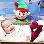 baby, infant, smiling, plush_toy, elf, holiday, christmas, festive, blanket, wooden_box, red_socks, cozy, cute, indoor, portrait, happy, decor, child, toy, background