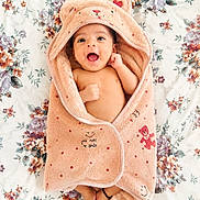 Shreyas joined the competition — help win amazing prizes! baby, smiling, towel, hooded_towel, teddy_bear, floral, bedspread, infant, cute, happy, wrapped, soft, cozy, child, small, feet, face, lying_down, expressive, blanket