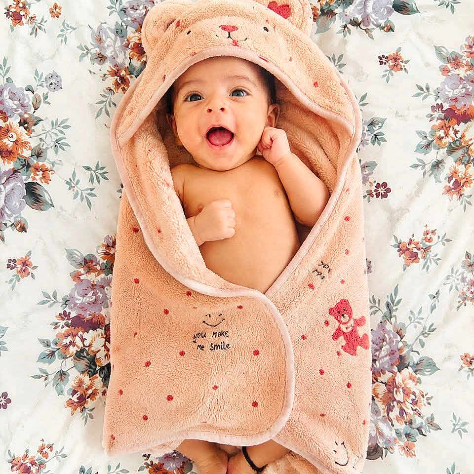 Shreyas joined the competition — help win amazing prizes! baby, smiling, towel, hooded_towel, teddy_bear, floral, bedspread, infant, cute, happy, wrapped, soft, cozy, child, small, feet, face, lying_down, expressive, blanket