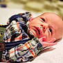 Jack Jack is registered to the contest to win money with this photo: baby, child, closeup, clothing, curious, cute, eyes, face, hand, indoors, infant, lying_down, newborn, plaid_shirt, portrait, skin, small_fingers, soft_surface, suspenders, tender_moment