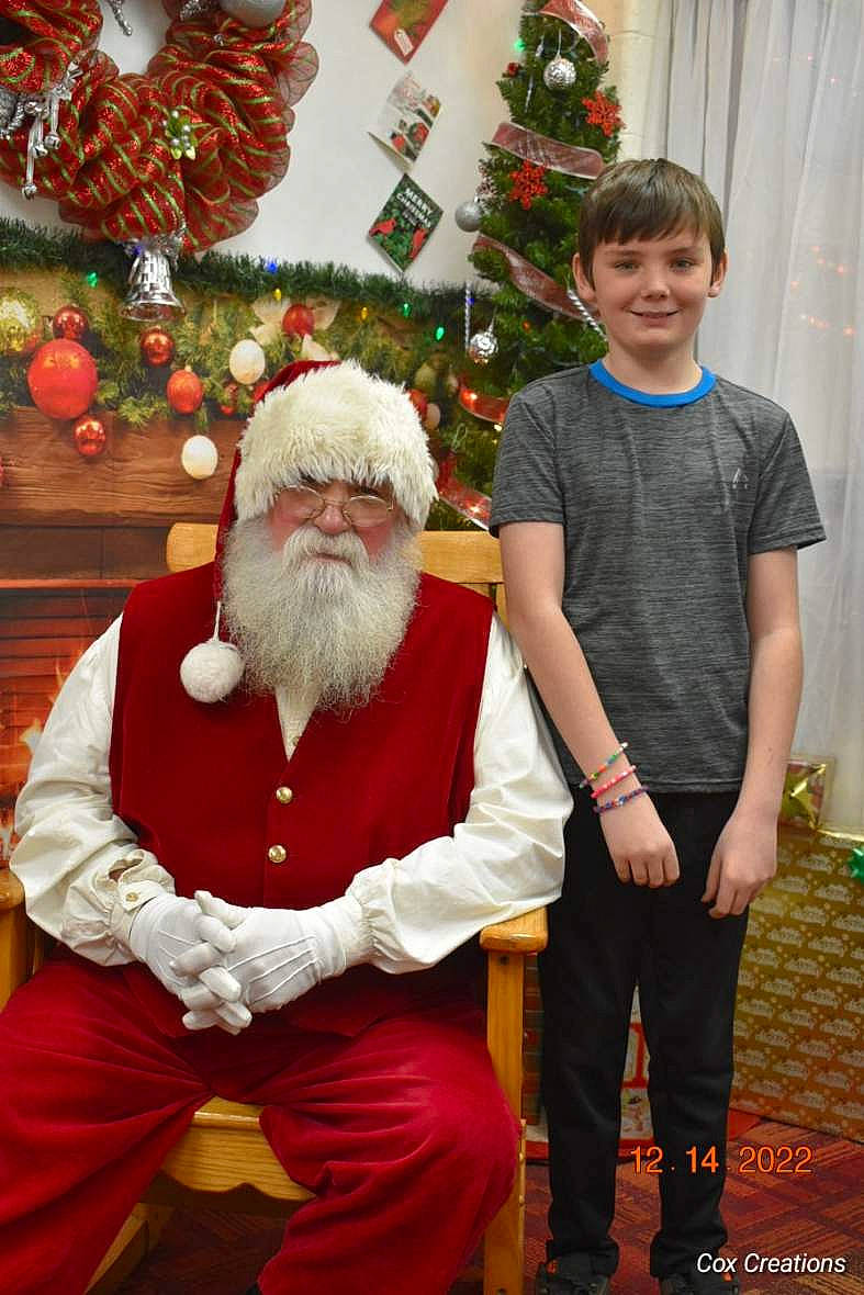 Tristan is registered to the contest to win money with this photo: beard, christmas, christmas_decoration, christmas_eve, christmas_ornament, christmas_tree, conifer, event, facial_hair, fun, green, happy, headwear, holiday, holiday_ornament, joy, lap, person, red, santa_claus