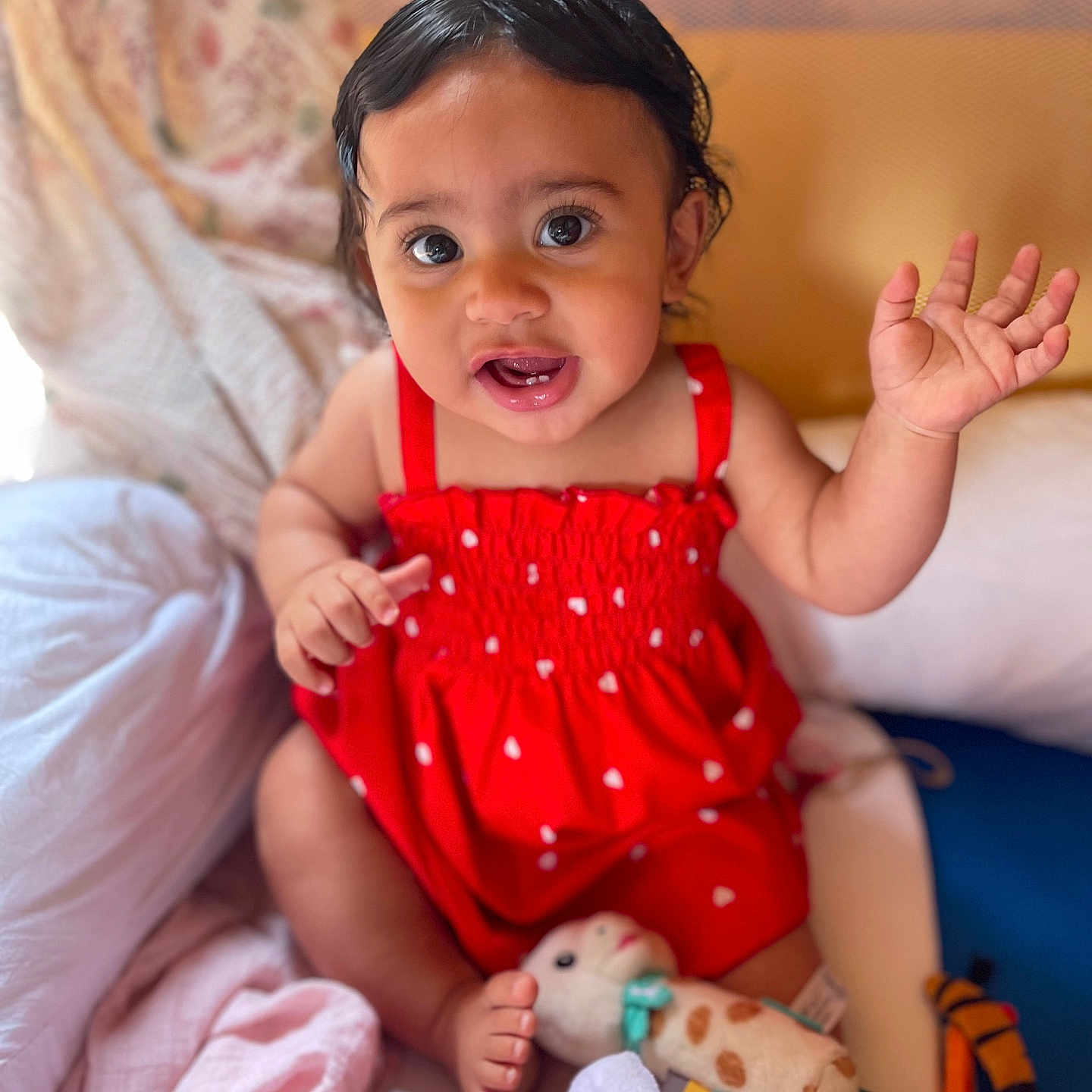Inaya participe au concours pour gagner de l'argent avec cette photo : baby, blanket, child, colorful, cute, face, feet, happy, head, indoors, infant, person, playing, plush, portrait, red_dress, sitting, smiling, toys, waving_hand