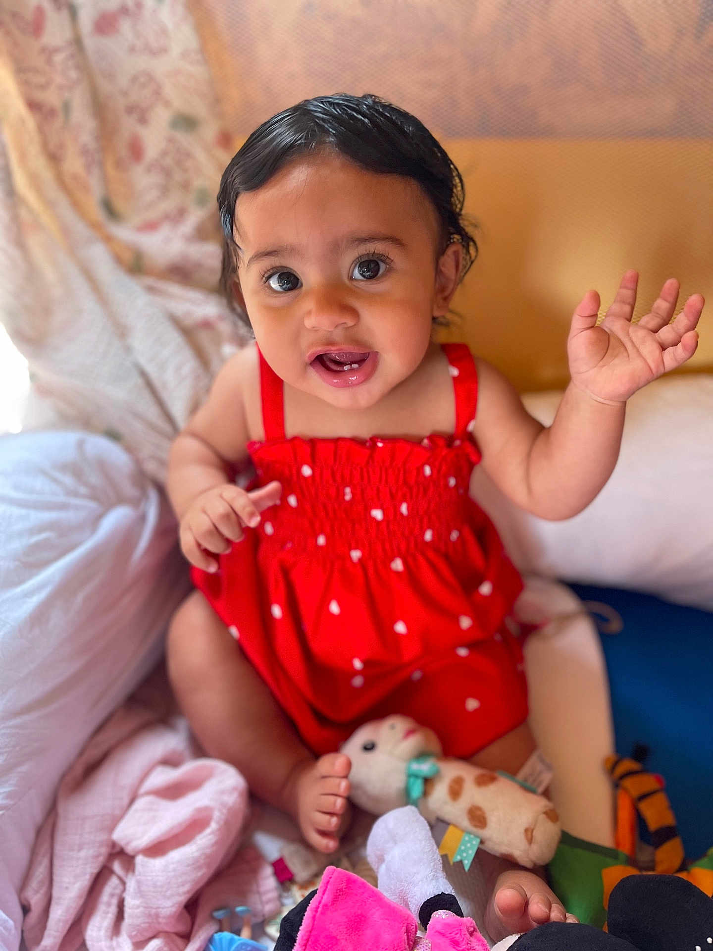 Inaya participe au concours pour gagner de l'argent avec cette photo : baby, blanket, child, colorful, cute, face, feet, happy, head, indoors, infant, person, playing, plush, portrait, red_dress, sitting, smiling, toys, waving_hand