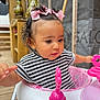 Inaya participe au concours pour gagner de l'argent avec cette photo : baby, child, curly_hair, cute, exploring, face, hair_bows, hands, indoors, looking_down, pink, playtime, portrait, seat, striped_clothing, toddler, toy, walker, wooden_floor, young_child