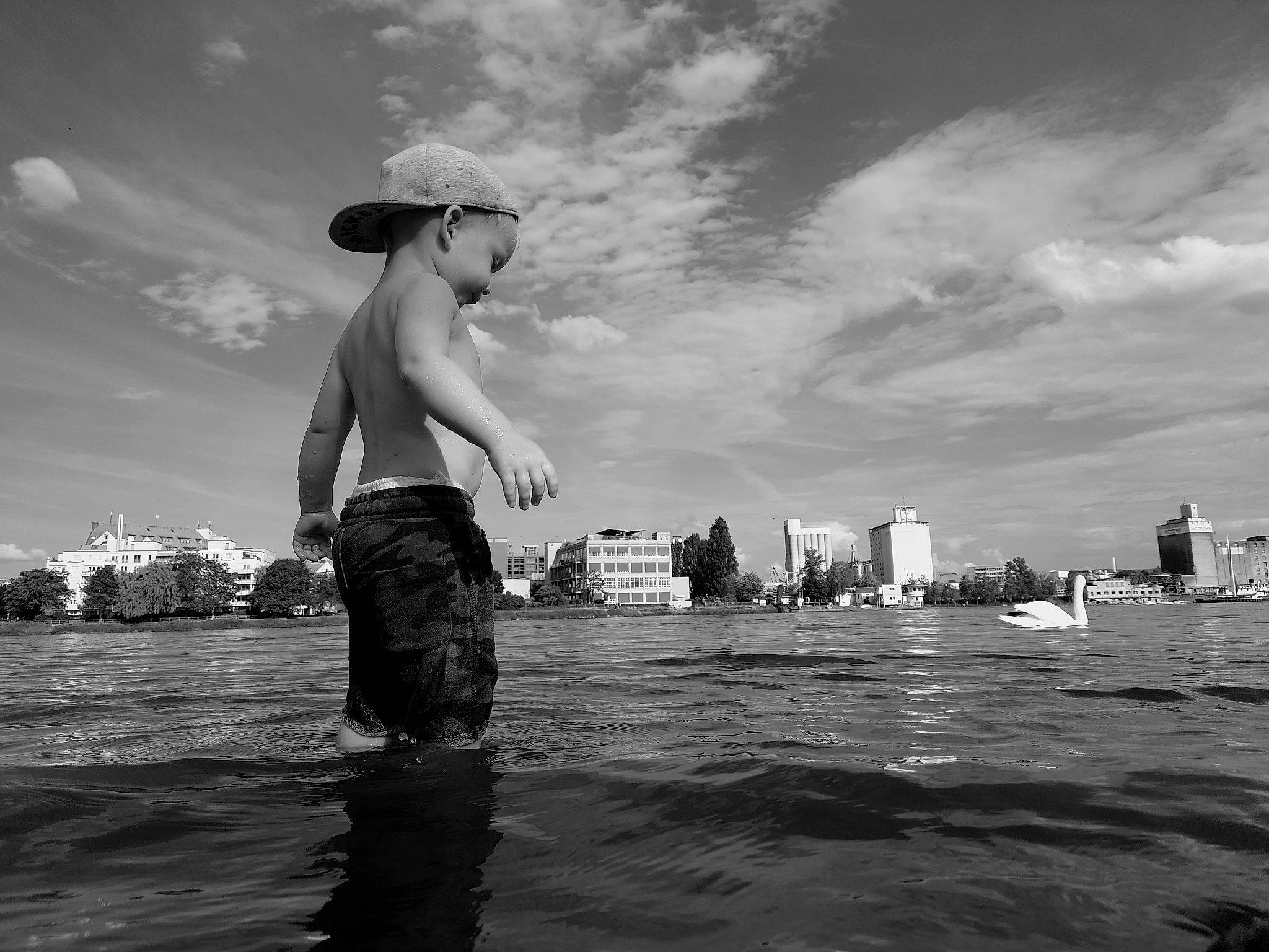 Nolhan participe au concours pour gagner de l'argent avec cette photo : black_and_white, cloud, eyewear, flash_photography, gesture, happy, hat, horizon, human_leg, lake, leisure, monochrome, monochrome_photography, ocean, people_in_nature, person, sky, standing, style, sun_hat
