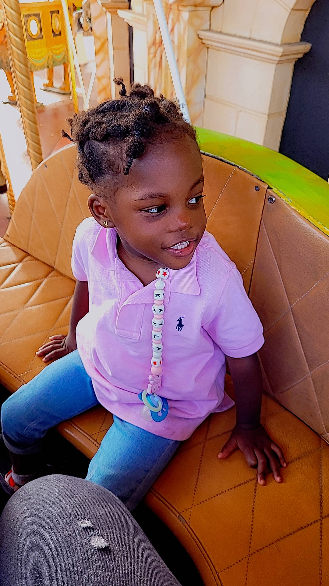 Kayla a rejoint le concours — aidez-le/la à gagner de superbes lots ! black_hair, car_seat, child, comfort, denim, fun, hairstyle, happy, jewellery, joy, leisure, magenta, mouth, necklace, person, sitting, skin, smile, t_shirt, thigh