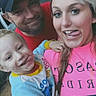 family, selfie, child, man, woman, smile, outdoor, grass, cap, pink_shirt, happy, tongue_out, casual_clothing, portrait, toddler, closeup, fun, people, daylight, playful
