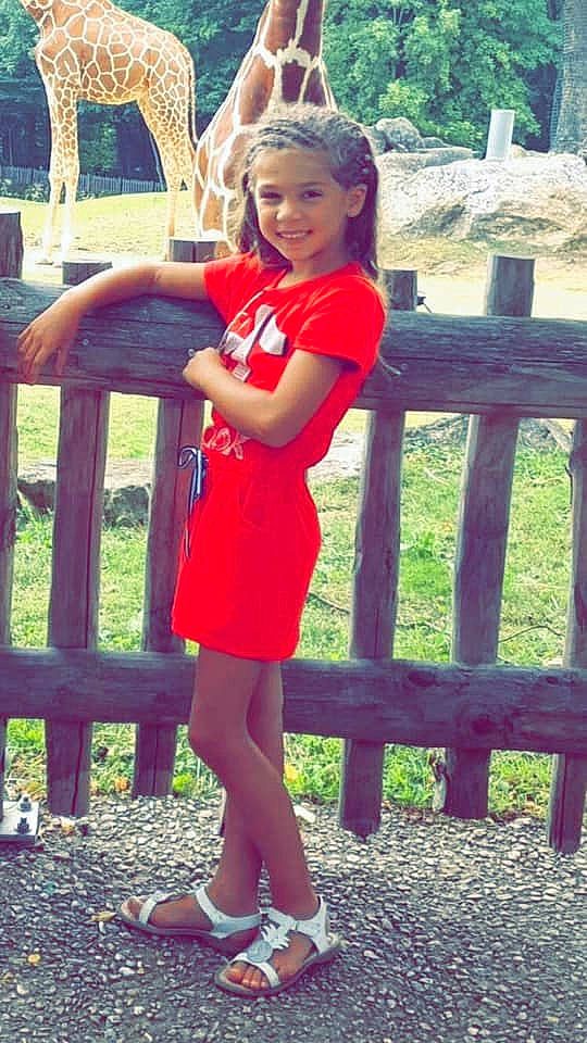 Aëlys participe au concours pour gagner de l'argent avec cette photo : fence, grass, green, hair, happy, head, joy, leisure, people_in_nature, person, photograph, pink, plant, shoe, shoulder, standing, style, summer, thigh, tree