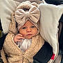 baby, infant, child, face, headband, bow, clothing, coat, zipper, car_seat, cushion, blanket, fur, soft, cute, portrait, indoors, person, young, bundle