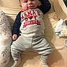 baby, infant, smiling, clothing, shirt, bed, bedding, pillow, pacifier, blanket, sock, striped_pants, person, cute, happy, lying_down, indoors, child, newborn, face