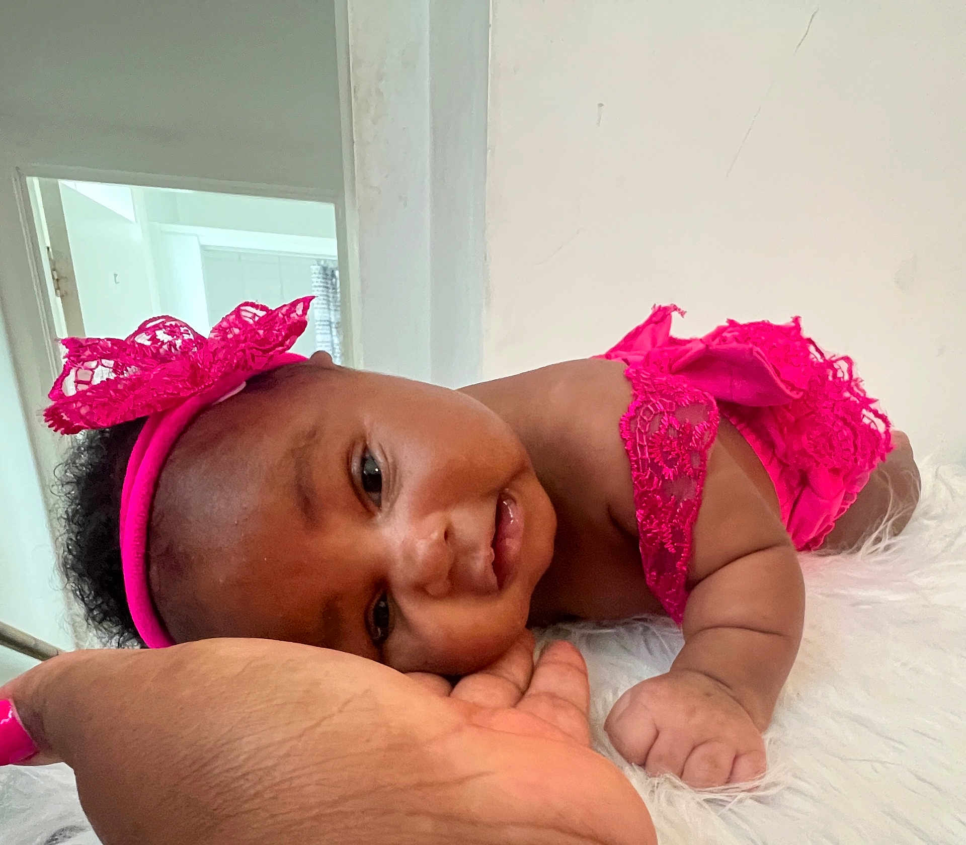 Khwezi is registered to the contest to win money with this photo: baby, infant, child, headband, pink, lace, hand, skin, face, eyes, smile, arm, fingers, soft, white, fur, indoor, person, cute, resting