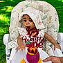 baby, infant, child, highchair, face, bonnet, hat, cake_topper, strawberry, dragonfruit, orange_slice, plate, hand, outdoor, grass, patterned_cushion, cute, celebration, portrait, photography
