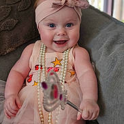 Indigo is registered to the contest to win money with this photo: baby, blue_eyes, child, couch, cozy, cute, dress, happy, headband, indoor, infant, pearl_necklace, person, pink, portrait, sitting, smiling, soft_toys, tutu, wand