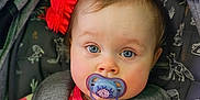 Indigo joined the competition — help win amazing prizes! baby, baby_girl, blue_eyes, car_seat, caterpillar_toy, child, closeup, cute, face, gray_straps, headrest, indoors, infant, pacifier, pink_clothing, portrait, red_toy, soft_lighting, striped_outfit, young_child