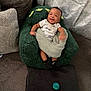 Jacai is registered to the contest to win money with this photo: baby, child, smiling, plush_chair, blanket, pacifier, couch, curtain, indoor, happy, knitted_blanket, toddler, black_socks, infant, cozy, furniture, seat, green, cute, person
