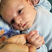 Dominik joined the competition — help win amazing prizes! baby, newborn, infant, hand, finger, tattoo, blue_clothing, blanket, floral_pattern, closeup, skin, face, expression, sleepy, person, holding, touch, gentle, soft_light, portrait