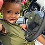 Kingsley participe au concours pour gagner de l'argent avec cette photo : child, smiling, car_interior, steering_wheel, green_clothing, window, flowers, pink_flowers, seat, seatbelt, person, portrait, young_child, curly_hair, hand, casual_wear, daylight, nature_outside, cute, happy