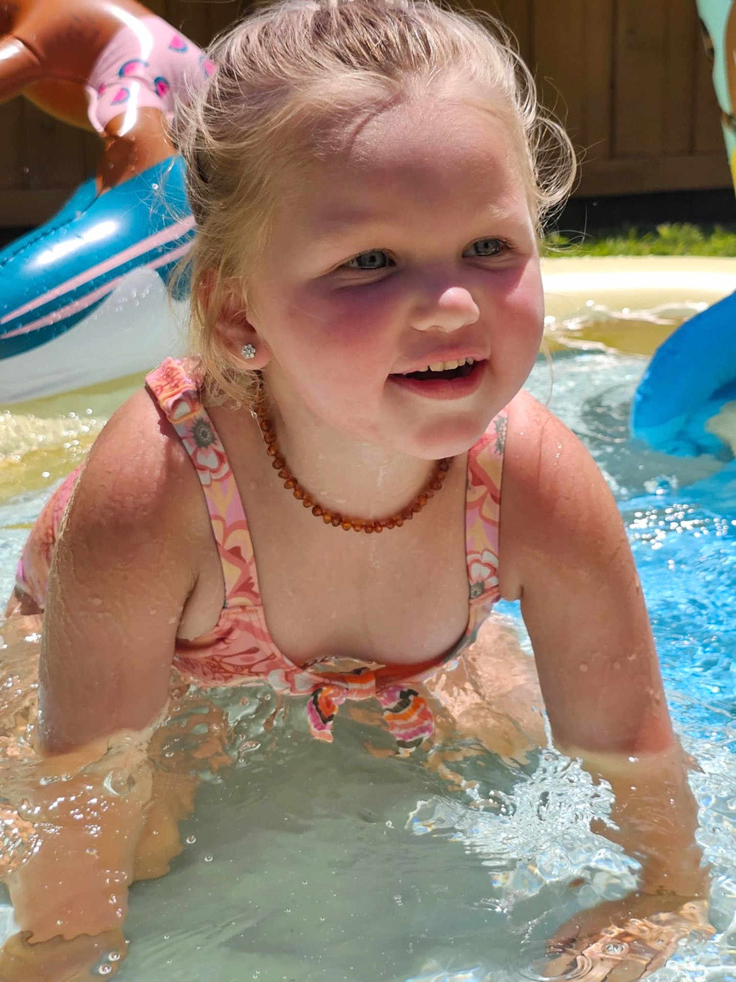 Evelyn joined the competition — help win amazing prizes! child, water, pool, splashing, smiling, swimsuit, summer, outdoor, happy, playing, wet, sunlight, necklace, earrings, inflatable, backyard, fun, cute, girl, daytime