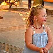 Evelyn joined the competition — help win amazing prizes! child, girl, smiling, sunset, outdoor, sidewalk, blonde_hair, earrings, necklace, blue_dress, happy, portrait, young, casual_clothing, daylight, warm_light, motion, cute, skin, person