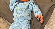 Coleson is registered to the contest to win money with this photo: baby, infant, blue_outfit, dinosaur_pattern, hat, footed_pajamas, cute, lying_down, soft_surface, newborn, child, clothing, sleepwear, cozy, small_hands, portrait, indoors, person, face, headwear