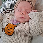 Ilona a rejoint le concours — aidez-le/la à gagner de superbes lots ! baby, bear_patch, bed, bedding, blanket, bow, child, comfort, cozy, cute, headband, indoors, infant, knitted_sweater, pacifier, pattern, peaceful, resting, sleeping, soft