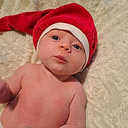 Ilona a rejoint le concours — aidez-le/la à gagner de superbes lots ! baby, infant, hat, red_hat, christmas_hat, blanket, skin, cute, child, portrait, newborn, lying_down, indoors, face, expression, holiday, soft_texture, chubby, young, headwear