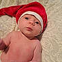 baby, infant, hat, red_hat, christmas_hat, blanket, skin, cute, child, portrait, newborn, lying_down, indoors, face, expression, holiday, soft_texture, chubby, young, headwear