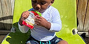 Landon is registered to the contest to win money with this photo: baby, barefoot, casual, child, curly_hair, daylight, green_chair, outdoor, person, playful, relaxing, shadow, shorts, sitting, snack_pouch, summer, sunlight, toddler, white_shirt, wooden_fence