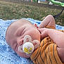 baby, blanket, child, clothing, face, grass, head, infant, knitted, nature, orange, outdoor, pacifier, park, peaceful, playground, relaxation, sleeping, slide, striped