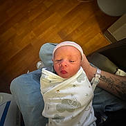 Nolan Keith joined the competition — help win amazing prizes! newborn, baby, swaddle, hospital, infant, hat, tongue_out, parent, wristband, tattoo, holding, wood_floor, blanket, close_up, portrait, cute, small, resting, bedside, human