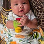 Avery is registered to the contest to win money with this photo: baby, infant, toy, blanket, clothing, face, hand, pattern, colorful, curious, child, cute, indoor, portrait, expression, skin, resting, fabric, playful, young