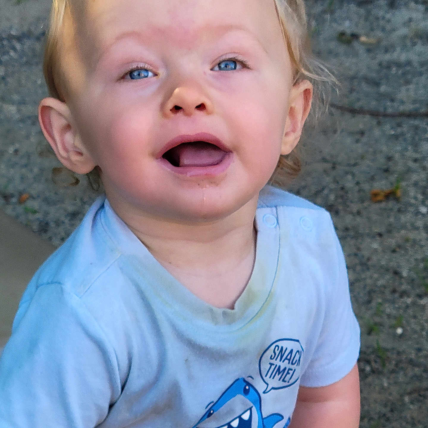 Able is registered to the contest to win money with this photo: blue_eyes, casual_clothing, child, cute, daylight, dirt, graphic_tee, gravel, happy, light_blue, messy_face, open_mouth, outdoor, person, playful, shark, shirt, short_hair, toddler, young_child