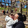 baby, closeup, daylight, family, flowering_tree, glasses, happy, headband, hug, jacket, love, nature, outdoor, park, person, portrait, smile, spring, trees, woman