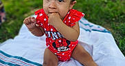 Sienna joined the competition — help win amazing prizes! baby, child, infant, girl, outdoor, grass, blanket, sitting, cute, red_clothing, minnie_mouse, hair_clips, fingers_in_mouth, portrait, happy, summer, playful, innocent, park, young