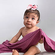 Sienna joined the competition — help win amazing prizes! adorable, baby, blanket, child, childhood, curious, cute, diaper, expression, indoors, infant, person, pink_bow, playful, portrait, purple_blanket, sitting, soft_background, studio, young