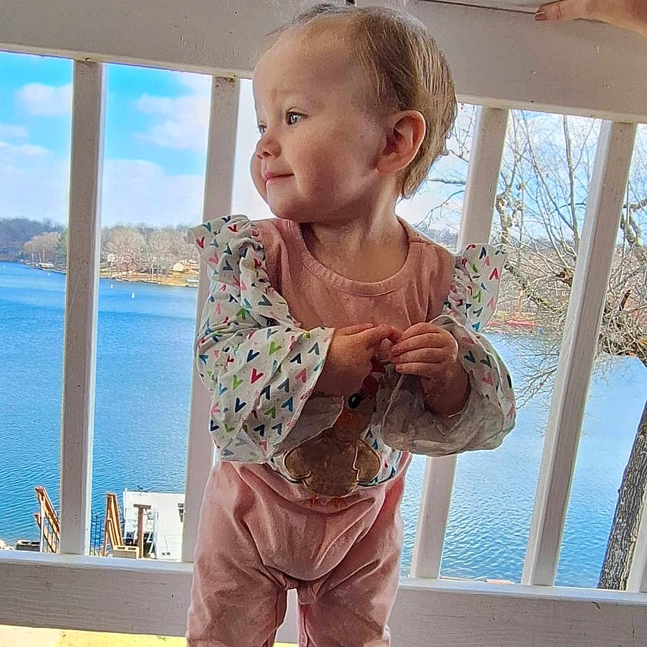 Everleigh joined the competition — help win amazing prizes! architecture, building, child, clothing, face, female, footwear, girl, head, house, housing, pants, person, photography, porch, portrait, shoe, water, waterfront, wood