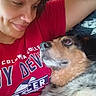 affection, black, brown, close_up, companion, cozy, cuddle, dog, fur, indoors, person, pet, portrait, red_shirt, relaxed, scruffy, selfie, sleepy, smiling, white