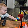 baby, child, cat, toy, table, chair, wood, indoor, furniture, person, animal, pet, curious, interaction, blue_eyes, gray_cat, highchair, short_hair, collar, domestic