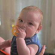 Simon is registered to the contest to win money with this photo: baby, child, teething_toy, blue_shirt, striped_clothing, indoor, person, cute, infant, hand, face, skin, cheek, curious, soft_light, portrait, young_child, holding, looking_at_camera, human
