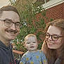 Simon joined the competition — help win amazing prizes! baby, child, adult, family, smile, glasses, outdoor, greenery, brick_wall, happy, portrait, casual_clothing, daylight, bench, people, nature, toddler, parent, father, mother